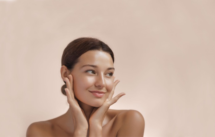 woman with glowing skin touching face